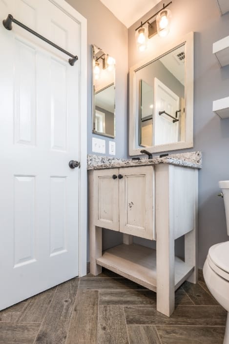 Farmhouse style bathroom remodel with wood look tile flooring and rustic vanity in Arlington, VA