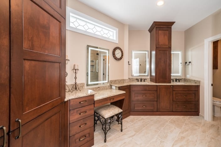 Spacious traditional master bath remodel with Alder wood cabinets in a burnt copper stain