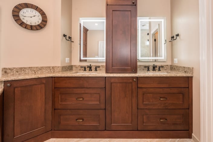 Master bath remodel with double vanity and custom cabinets for storage between sinks