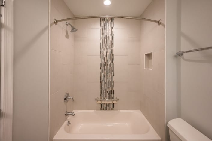 Vertical glass tile feature in shower stall with curved shower curtain bar in fairfax station bath remodel