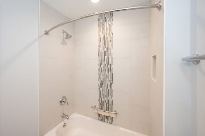 bathroom remodel in Fairfax Station with vertical glass tile feature and cream tiles