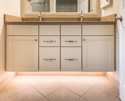 Koch vanity cabinets and Silestone countertop are paired with under cabinet lighting with floating feature