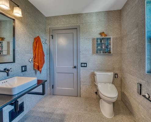 Custom Arlington bathroom remodel industrial chic with floating sink and stone tile walls