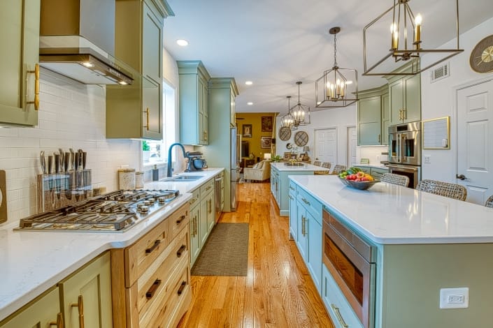 Custom kitchen remodel Gainesville va with sage green double islands and Viaterra Quartz countertops