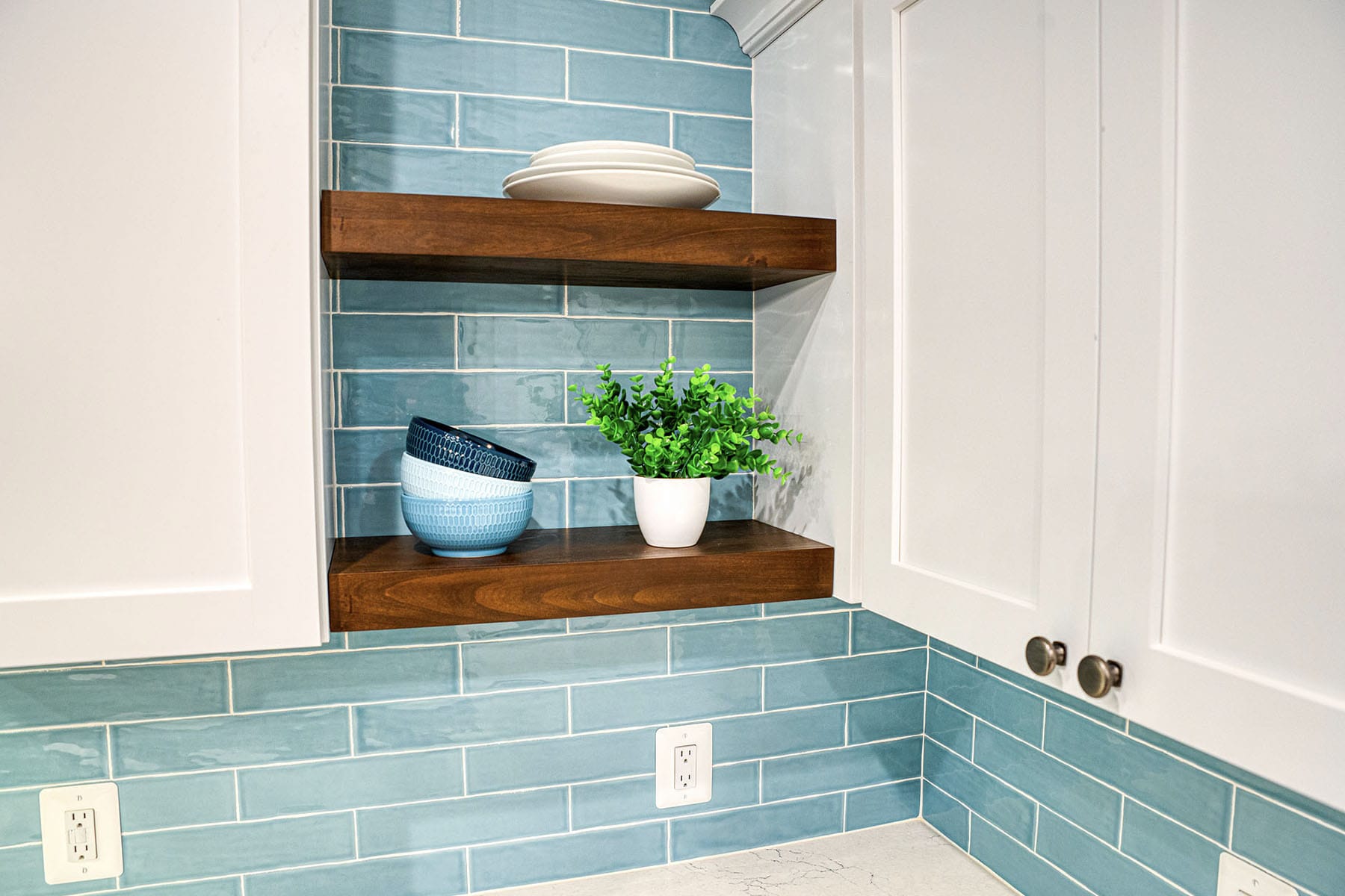 Open shelves with teal subway tiles