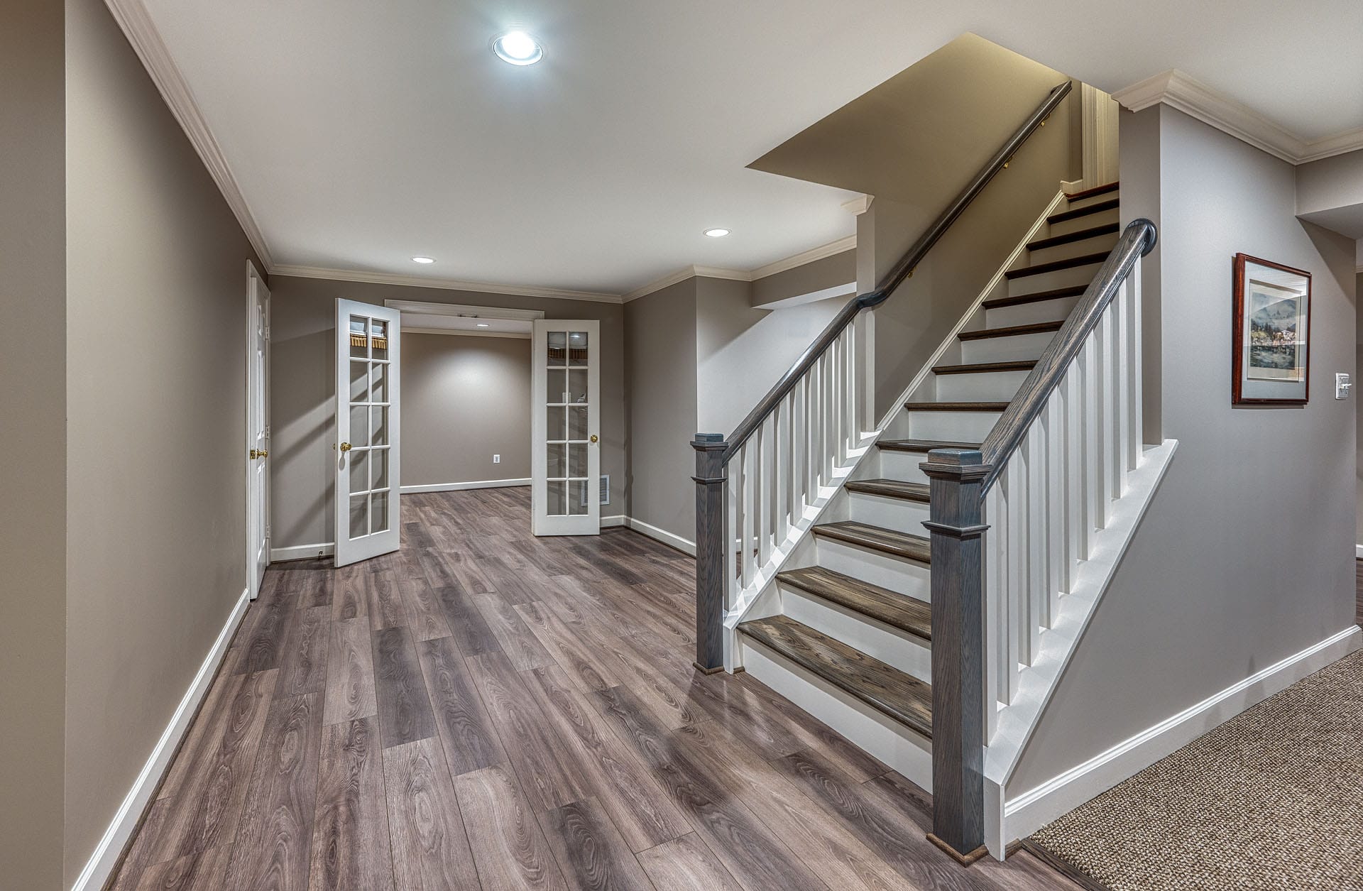 Basement remodeling Springfield, VA featuring new flooring, stair treads, rails and doors