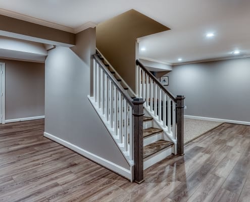 Springfield basement remodel with Luxury Vinyl Plank flooring in Chesapeake and red oak stair treads