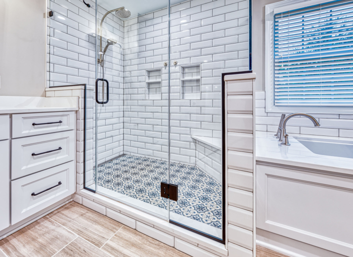 white vanity and custom shower stall with patterned shower floor