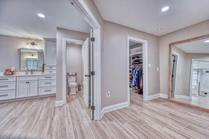 expansive bathroom remodel includes water closet and large walk in clothes closet.