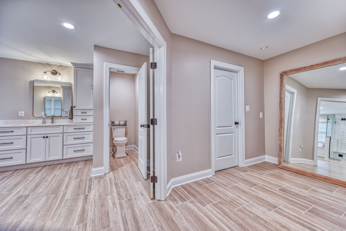 expansive bathroom remodel includes water closet and large walk in clothes closet.