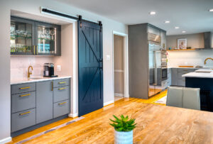 modern kitchen remodel with gray cabinets featuring a wet bar with sliding barn door for pantry
